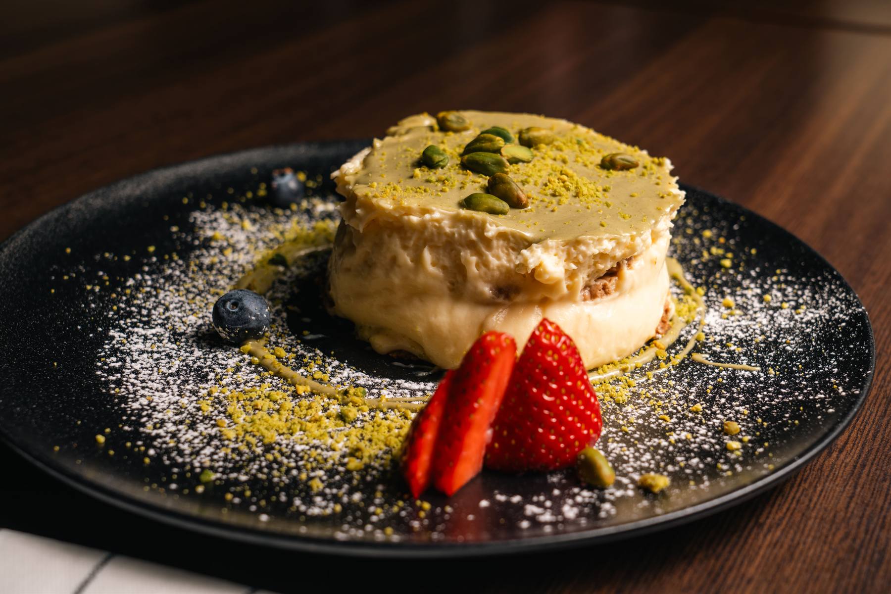 Hausgemachtes Pistazien-Tiramisù auf dunklem Teller